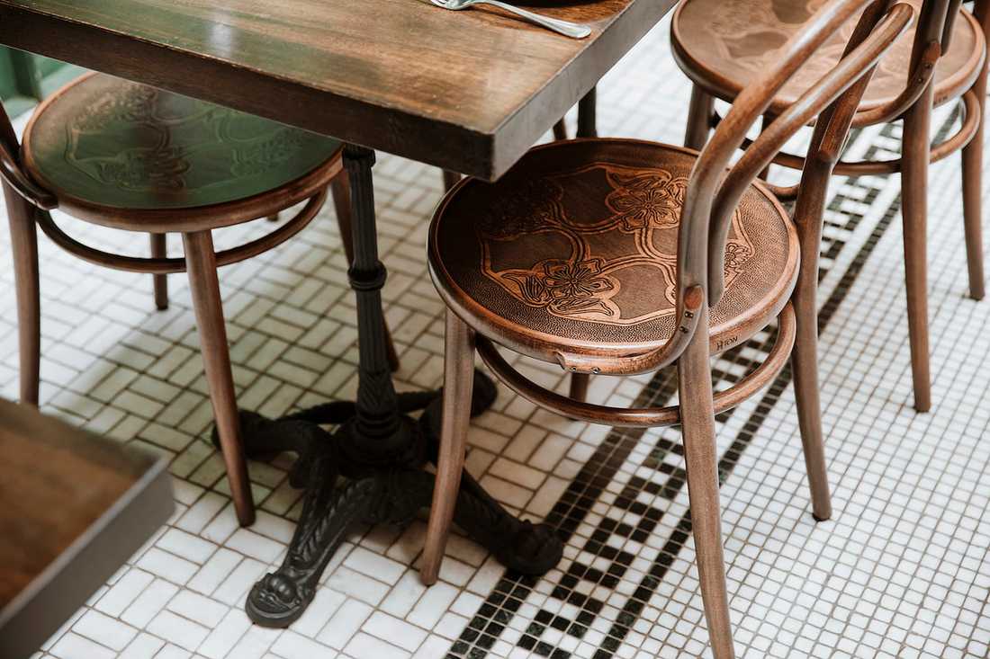 Aménagement d'un restaurant bistrot et tropical -  table sur un sol à petits carreaux