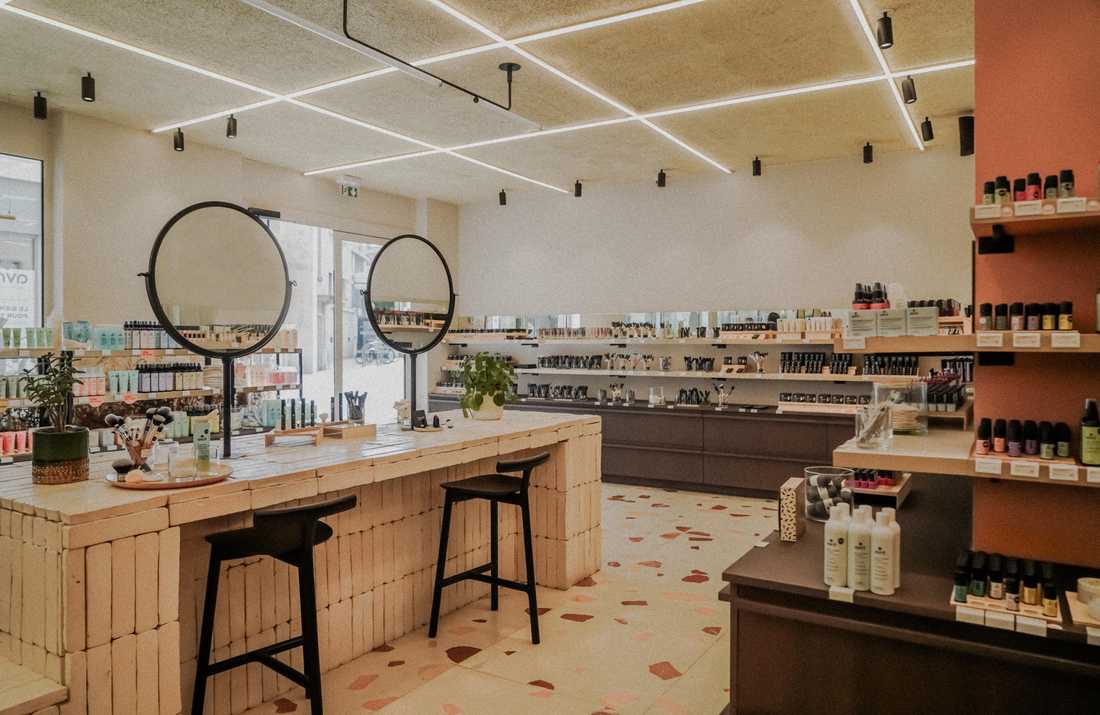 Aménagement intérieur de la boutique de cosmétiques bio Avril à Antibes, avec comptoir en brique de terre cuite et sol en terrazzo